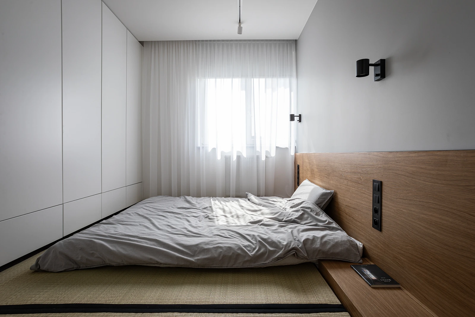 Minimalistyczna sypialnia w stylu japońskim, zaprojektowana przez Mirai Studio. 